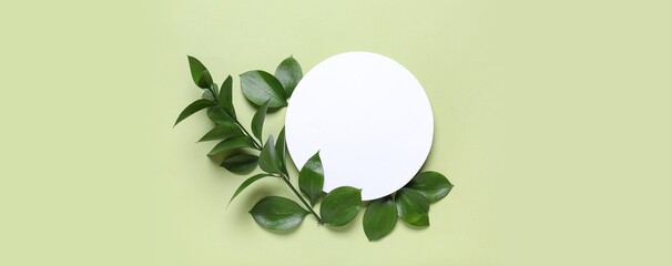 Blank card and leaves on green background