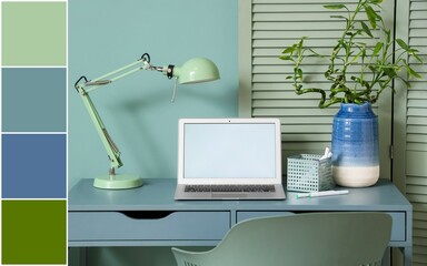 Comfortable workplace with modern laptop and lamp near mint wall. Different color patterns