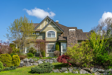 Two story stucco luxury house with nice spring blossom landscape in Vancouver, Canada, North America. Day time on May 2025.