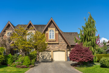 Two story stucco luxury house with nice spring blossom landscape in Vancouver, Canada, North...