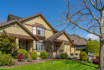 Two story stucco luxury house with nice spring blossom landscape in Vancouver, Canada, North...
