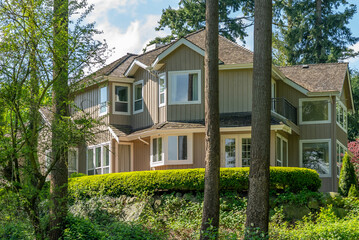 Two story stucco luxury house with nice spring blossom landscape in Vancouver, Canada, North...