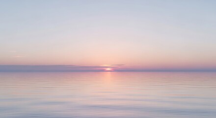 Fototapeta premium Serene sunset over a calm ocean with soft pastel sky and gentle water reflections.