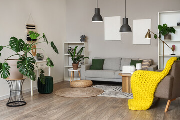 Interior of stylish living room with grey sofa, armchair and wooden coffee table at evening
