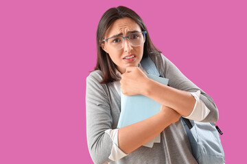 Beautiful young afraid woman with books on purple background