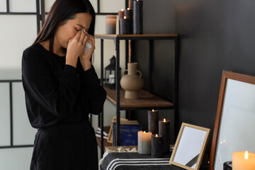 Mourning young Asian woman crying at funeral