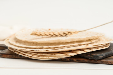 Tasty thin lavash on white wooden background, closeup