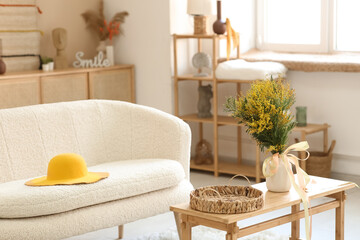 Vase with beautiful mimosa flowers on table in living room