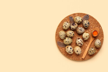 Board and wooden spoon with fresh quail eggs on beige background