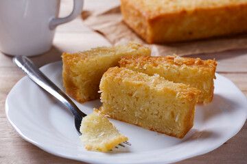 Traditional homemade cassava cake whit coconut on a rustic wooden table