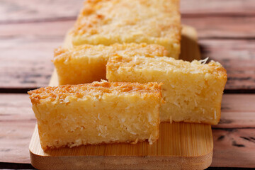 Traditional homemade cassava cake whit coconut on a rustic wooden table