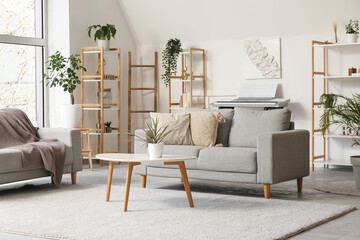 Interior of stylish living room with shelving unit, sofas and coffee table