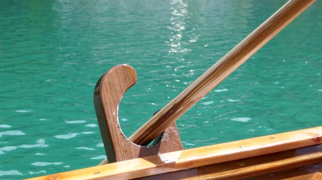 Gondola boat ride looking at oar handle rowing in oarlock with turquoise water