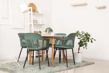 Interior of light dining room with table and shelf unit