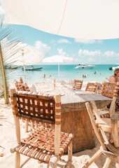 caribbean beach club wooden table setting with turquoise ocean view – tropical island luxury dining concept