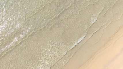Beach sand background for summer vacation concept. Beach nature and summer seawater with sunlight light sandy beach Sparkling sea water	
