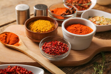 Cutting board with fresh aromatic spices on wooden table