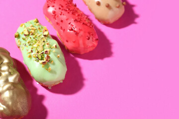 Delicious glazed eclairs on pink background