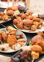 luxury caribbean fusion food plates close up with grilled corn mini burger skewer and fritters at beach restaurant