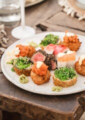 close up luxury sushi platter in caribbean beach club restaurant saint martin with blurred dishes in background and champagne glass