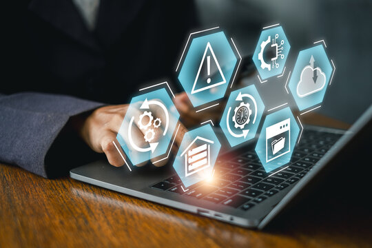 Businessperson using laptop with digital icons representing disaster recovery and data protection.