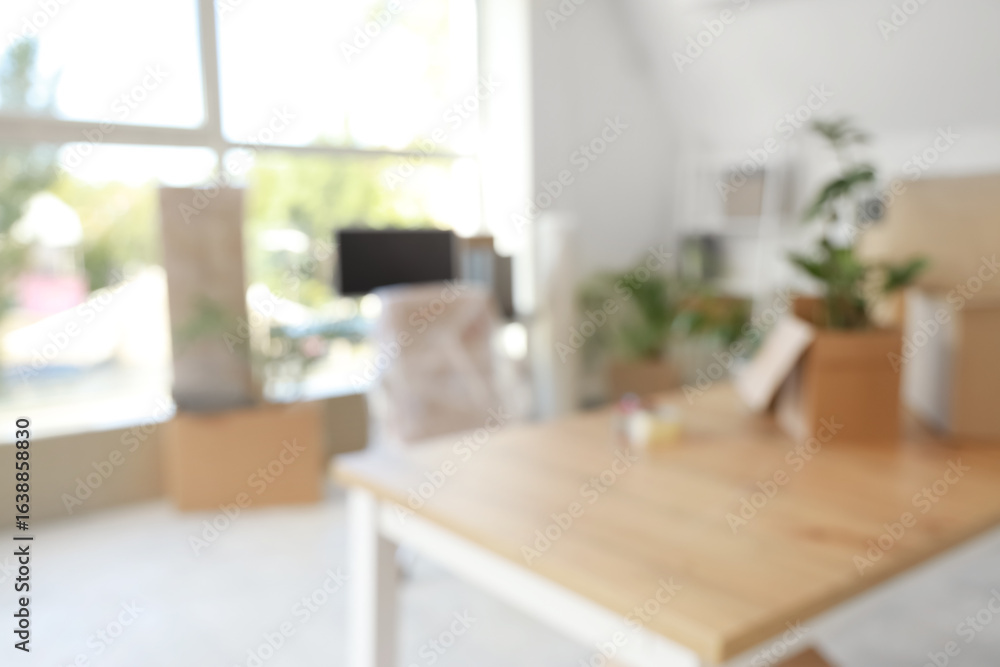 Poster blurred view of desks with cardboard boxes in office on moving day