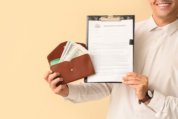 Male real estate agent with house rental agreement and wallet on beige background, closeup