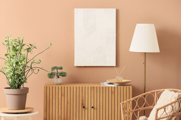Chest of drawers, armchair, floor lamp, houseplant and picture on brown wall in room