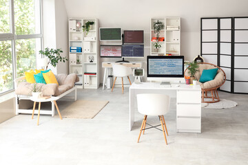Interior of light programmer's office with desks, shelf units and sofa