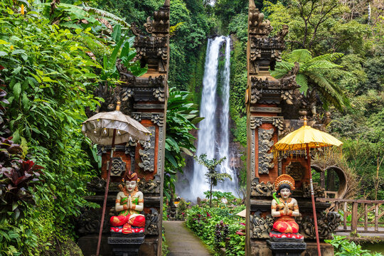 Gitgit waterfall in Northern Bali, flanked by the statues at the entryway, fashioned in traditional Balinese design.
