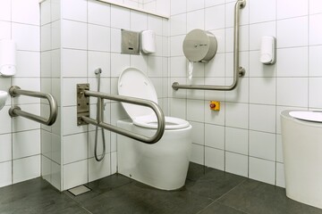 A modern toilet surrounded by safety grab bars design for accessibility, catering to people with...