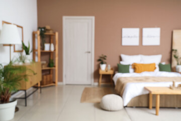 Interior of stylish bedroom with cozy bed, wooden furniture and white door