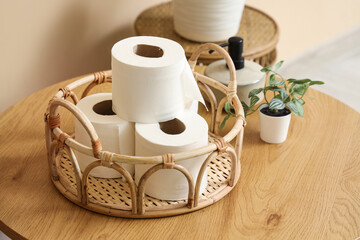 Basket with rolls of toilet paper on table in restroom, closeup