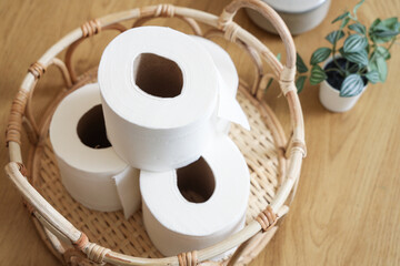 Basket with rolls of toilet paper on table in restroom, closeup