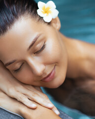 Naklejka premium Close-Up of Serene Woman with Flower Resting by Pool in Spa Concept
