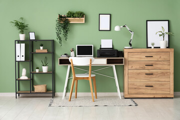 Workplace with modern printer, laptop and desk lamp in stylish home office