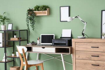Workplace with modern printer, laptop and desk lamp in stylish home office