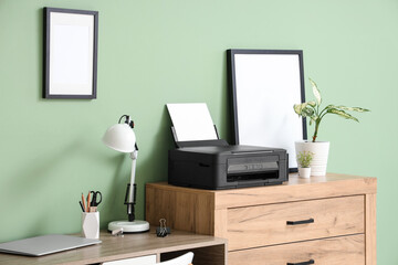 Chest of drawers with modern printer in stylish home office