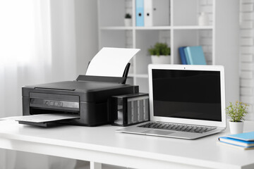 Stylish workplace with modern printer and laptop in light home office
