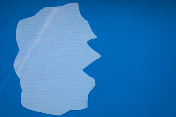 A torn sheet of lined paper lies on a rich blue background, symbolizing the loss of information,...