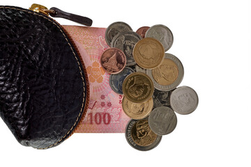 Collection of Assorted Coins and Bills Spilling From a Black Leather Wallet on a White Background