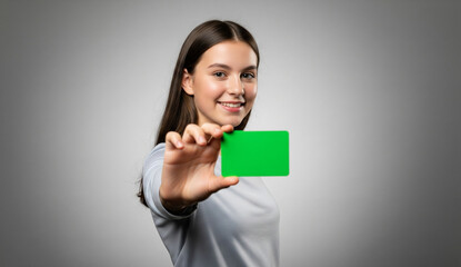 A cheerful young model presents a blank green screen card, ready to be customized with your message, logo, or design for marketing and promotional content.
