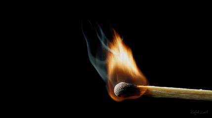 A match ignites, producing a vivid flame and smoke against a dark background, symbolizing fire and energy.