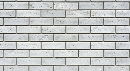 Fototapeta premium Close up of a weathered white brick wall showing a repeating pattern of rectangular bricks with visible texture and mortar lines