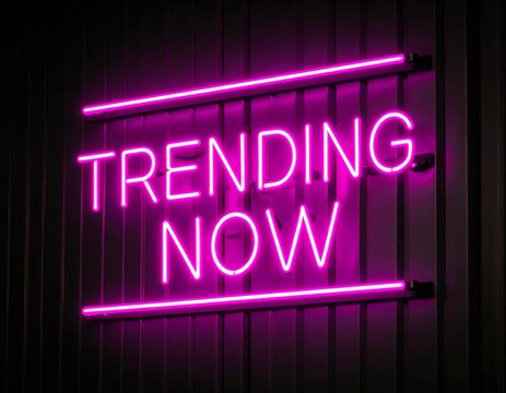 Vibrant pink neon sign on a dark wall, displaying "Trending Now