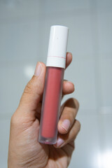 hand holding a bottle of lipstick