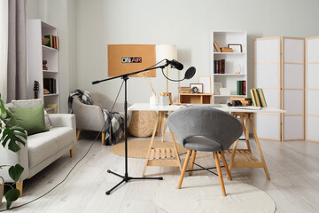 Interior of podcaster's studio with workplace, sofa and bookshelves