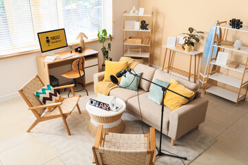 Interior of podcaster's studio with workplace, sofa and armchairs