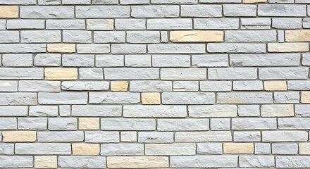 Obraz premium Close up textured view of a weathered light gray stone brick wall with subtle hints of yellow and pale blue creating a rustic and natural architectural background pattern