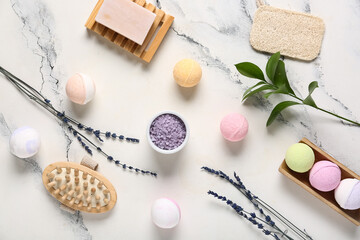 Bath bombs with sea salt, soap, massage brush and lavender flowers on marble background